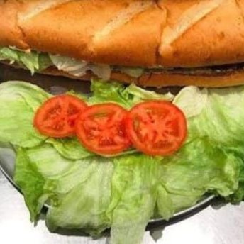 A juicy loaded burger with large fries and some sauce